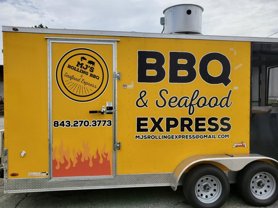 Bright yellow 'BBQ & Seafood Express' concession trailer with flame-motif graphics