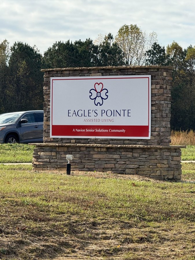 'Eagle's Pointe' cream community entrance monument in a landscaped tree-lined setting