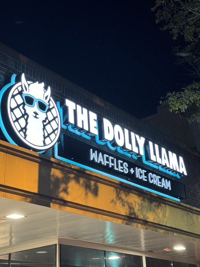 'THE DOLLY LLAMA WAFFLES + ICE CREAM' storefront channel letters lit against a dusk sky