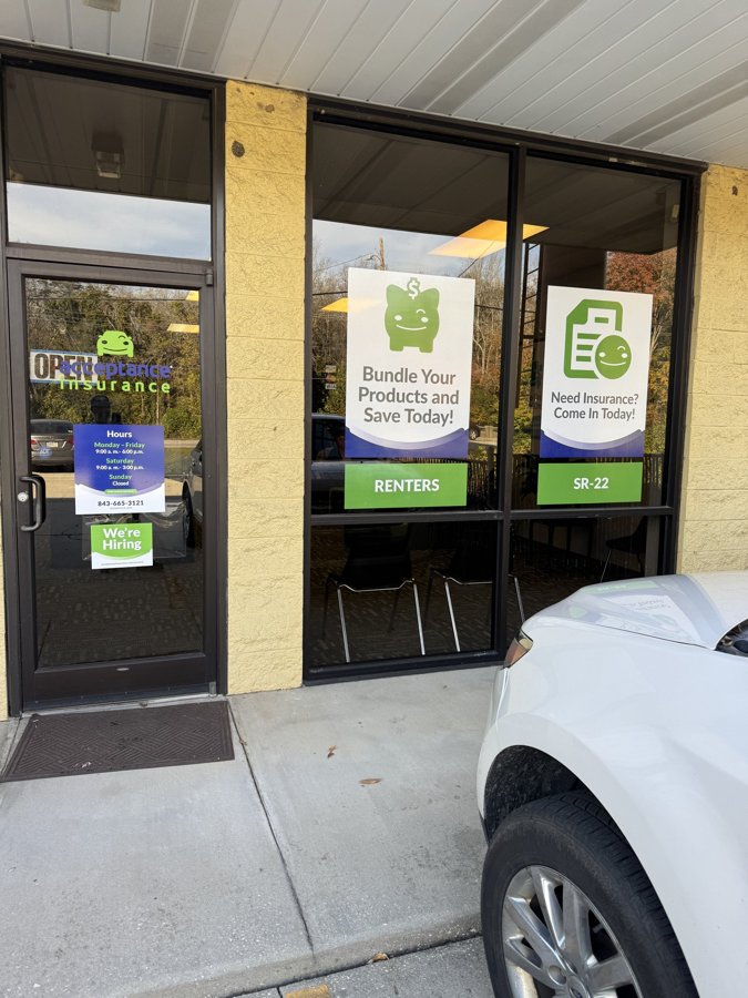 Acceptance Insurance storefront with promotional window graphics and dimensional wall signage