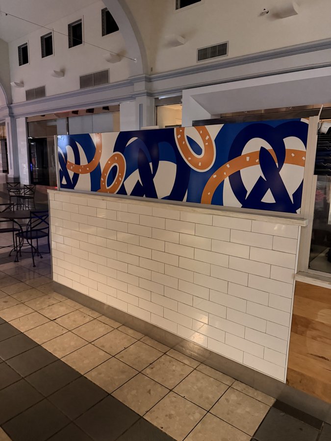 Auntie Anne's interior with blue and orange pretzel-themed wall wrap