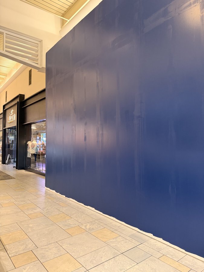 Bath & Body Works dark blue construction hoarding wrapping a mall build-out