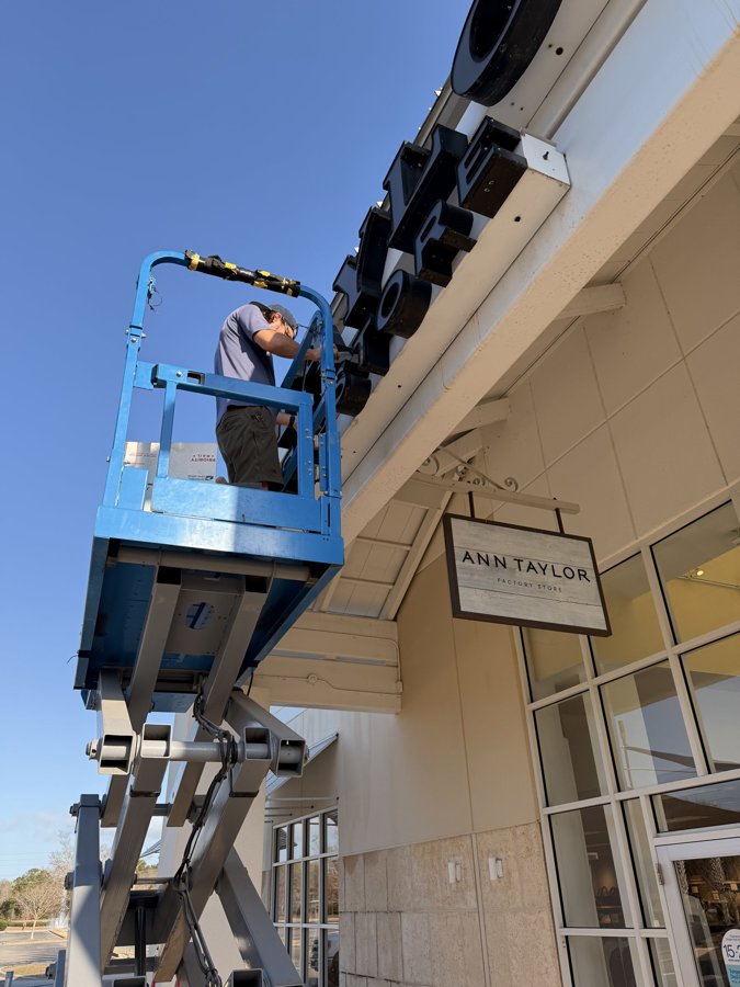 Blue boom lift positioned for storefront sign installation