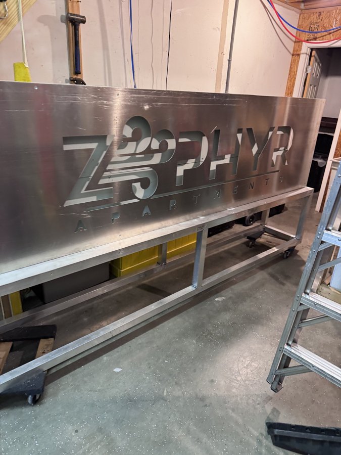 Zephyr metal dimensional letters laid out in shop for assembly