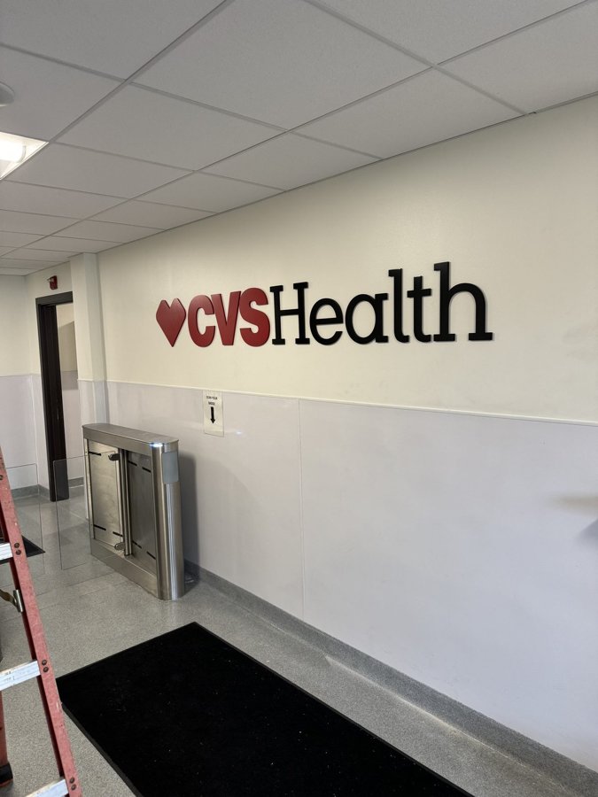 Dimensional 'CVS Health' logo and red heart mounted on an interior corporate lobby wall