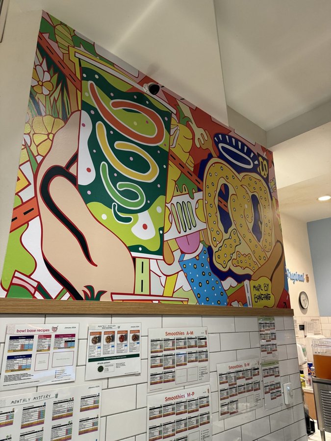 Vibrant multi-color abstract mural installed on the interior wall of a food-shop lobby