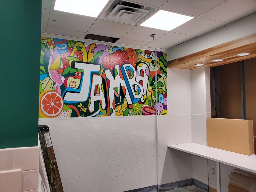 Full-wall tropical 'JAMBA' interior mural in bright citrus colors installed at a smoothie shop