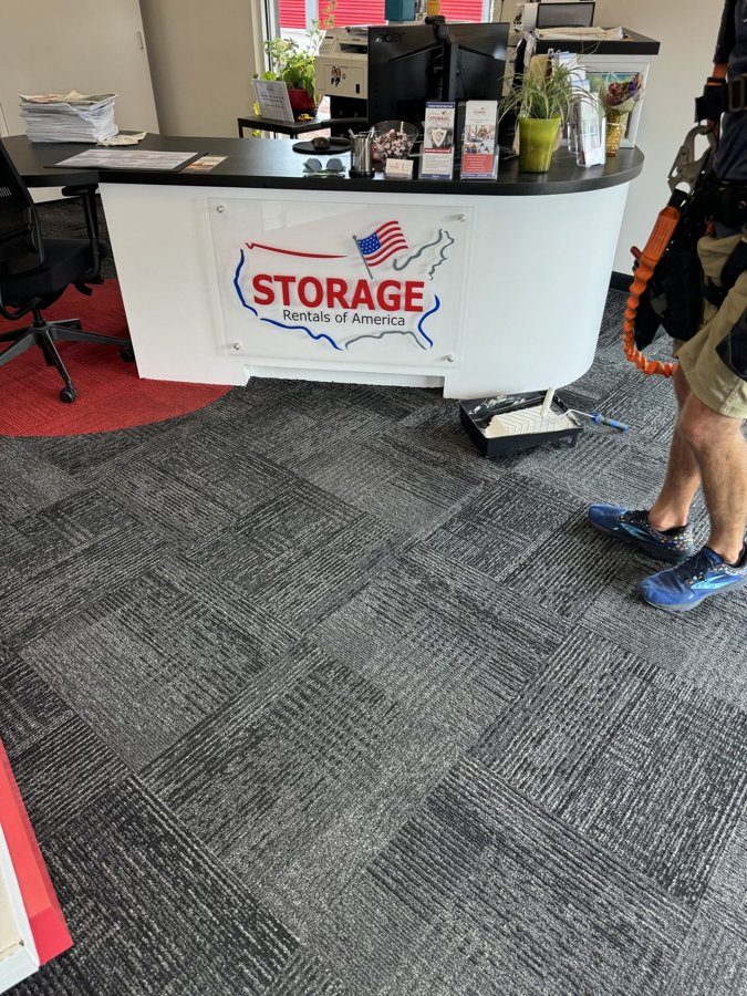 'STORAGE Rentals of America' logo panel mounted on a white curved reception counter
